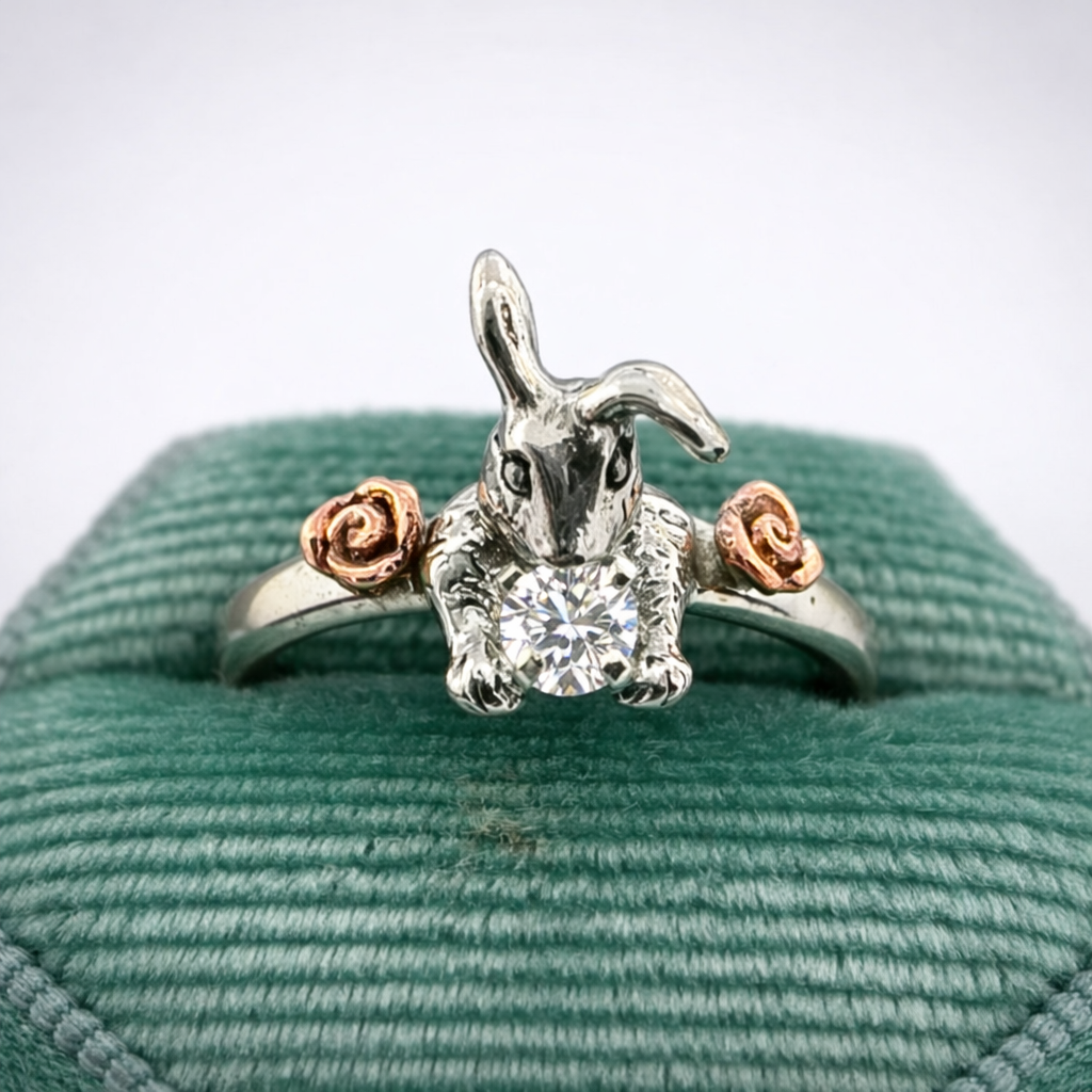 Hoppy Ever After bunny ring with moissanite and 14k rose gold flower accents displayed in a green ring box — handmade nature-inspired rabbit engagement ring by Teri Lee Jewelry — box not included