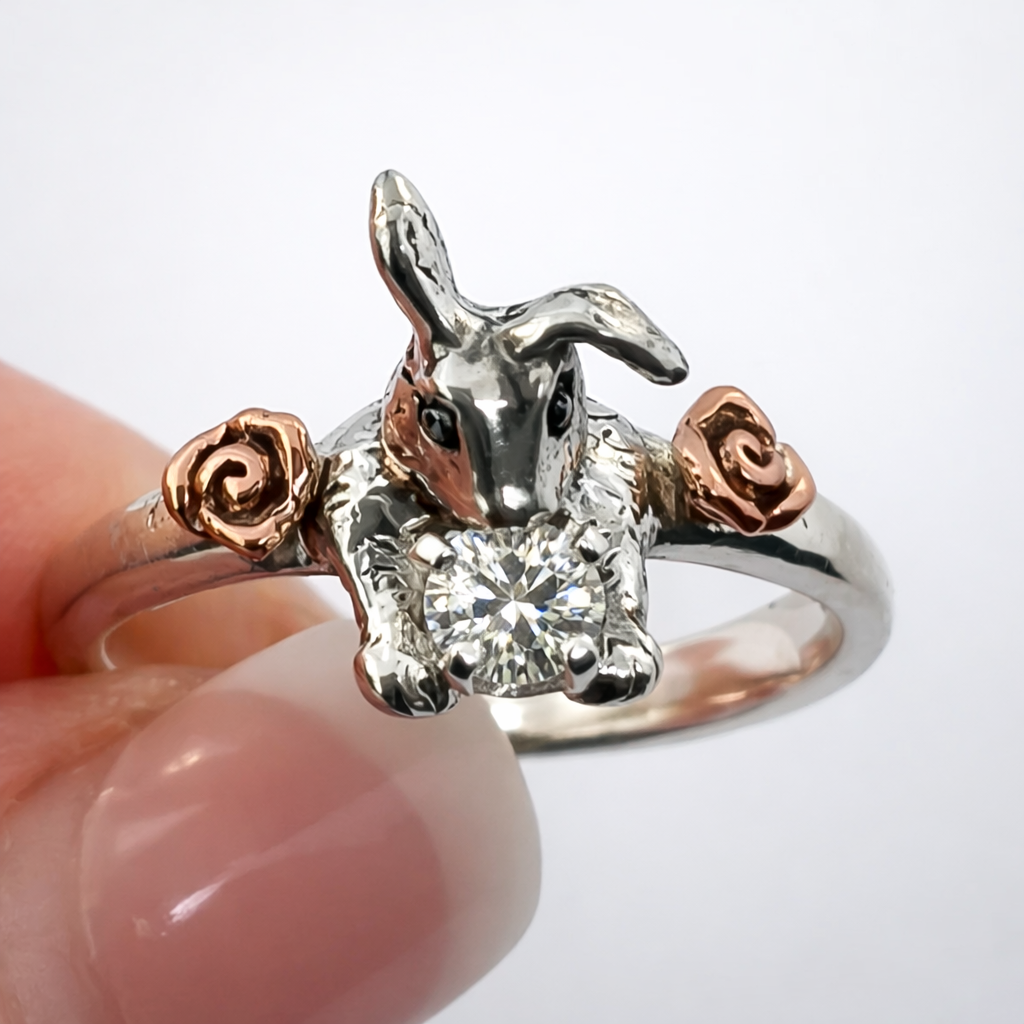 Hoppy Ever After bunny ring with moissanite gemstone and solid 14k rose gold flower accents on white background — handmade rabbit engagement ring by Teri Lee Jewelry

