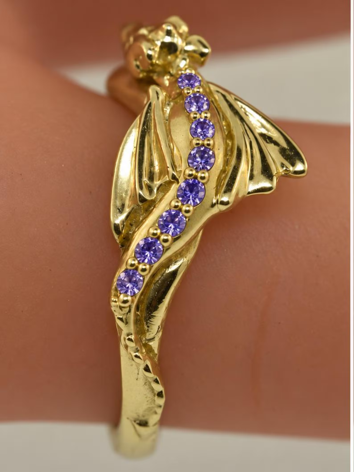 Gold Baby Dragon ring with amethyst gemstones, shown on a finger as a custom gemstone example.